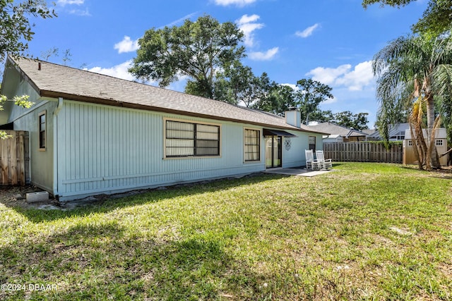 rear view of property featuring a lawn