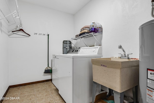 washroom featuring tile patterned floors, sink, washer and clothes dryer, and electric water heater