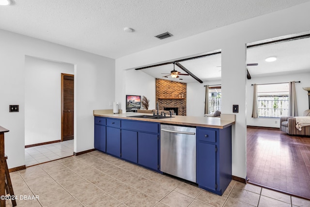 kitchen featuring blue cabinets, sink, a brick fireplace, light tile patterned floors, and dishwasher