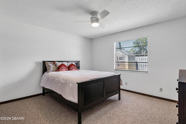 carpeted bedroom with ceiling fan and a textured ceiling