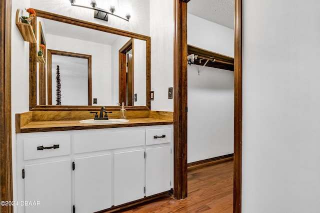 bathroom with vanity, hardwood / wood-style flooring, and a textured ceiling