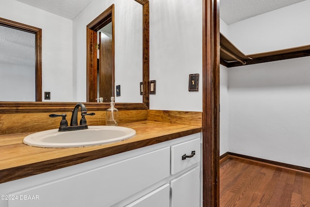 bathroom featuring vanity, hardwood / wood-style floors, and a textured ceiling