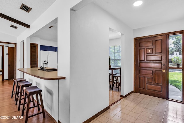 tiled entrance foyer featuring a healthy amount of sunlight and sink