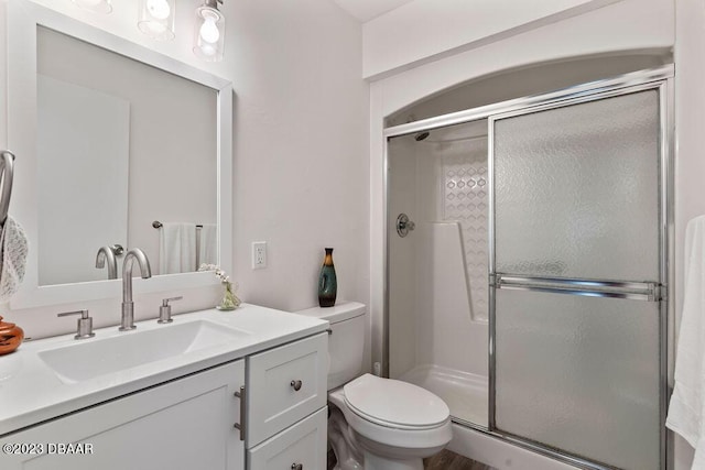 bathroom with vanity, an enclosed shower, and toilet