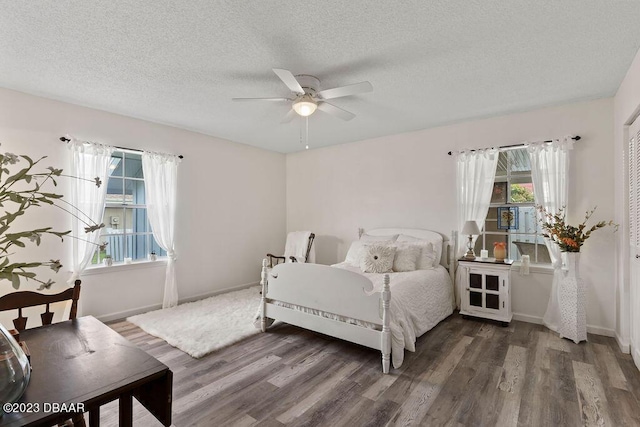 bedroom featuring ceiling fan, a textured ceiling, and dark hardwood / wood-style flooring