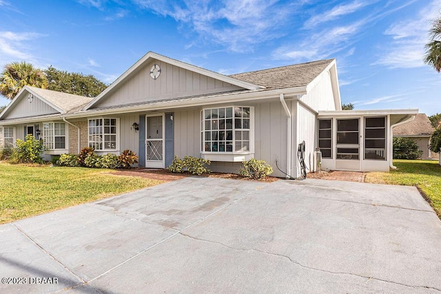 ranch-style home with a sunroom and a front lawn