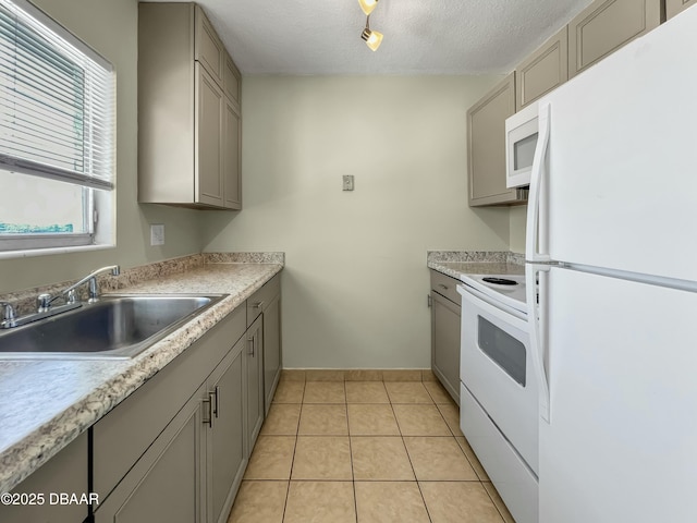 kitchen featuring gray cabinets, white appliances, and a sink