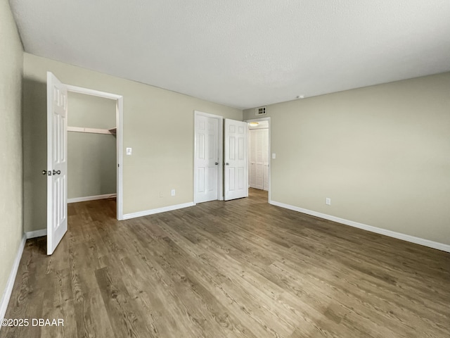 unfurnished bedroom featuring baseboards and wood finished floors