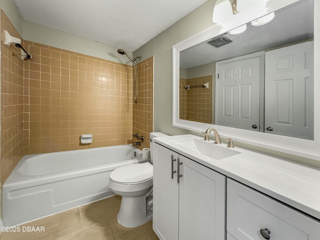 bathroom with vanity, visible vents, a textured ceiling, bathing tub / shower combination, and toilet