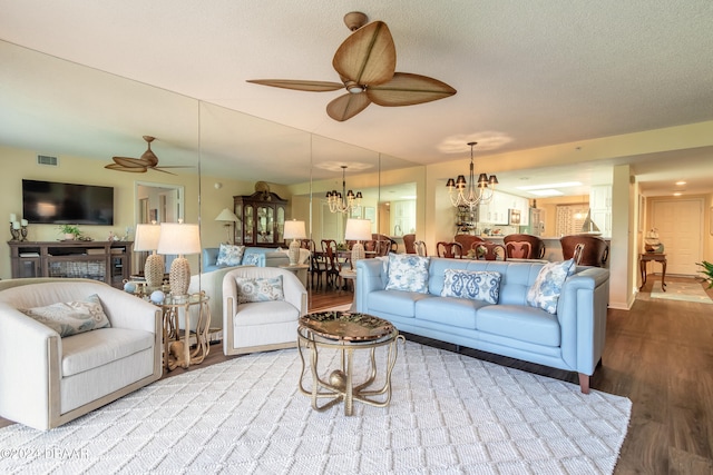 living room with a textured ceiling, hardwood / wood-style flooring, and ceiling fan with notable chandelier