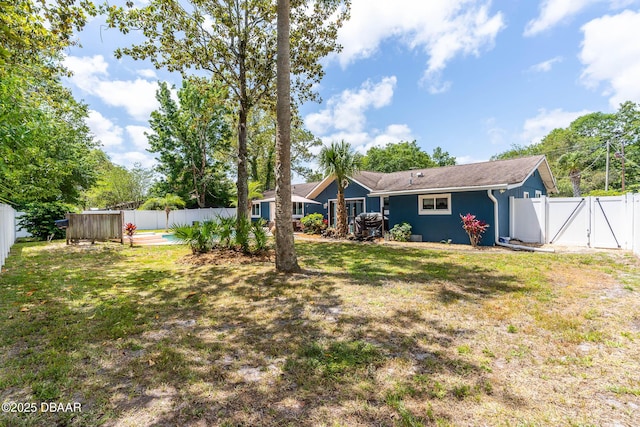 view of yard featuring a fenced backyard and a gate