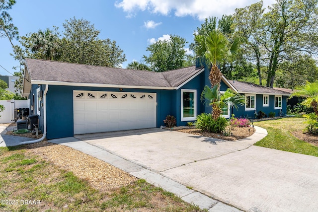 ranch-style house featuring stucco siding, a front lawn, concrete driveway, and an attached garage