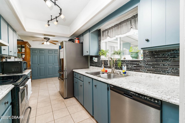 kitchen featuring light countertops, appliances with stainless steel finishes, decorative backsplash, and a sink
