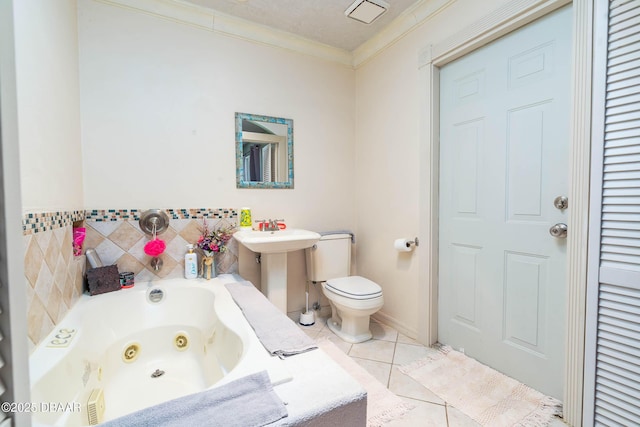 bathroom featuring ornamental molding, toilet, a jetted tub, and tile patterned flooring