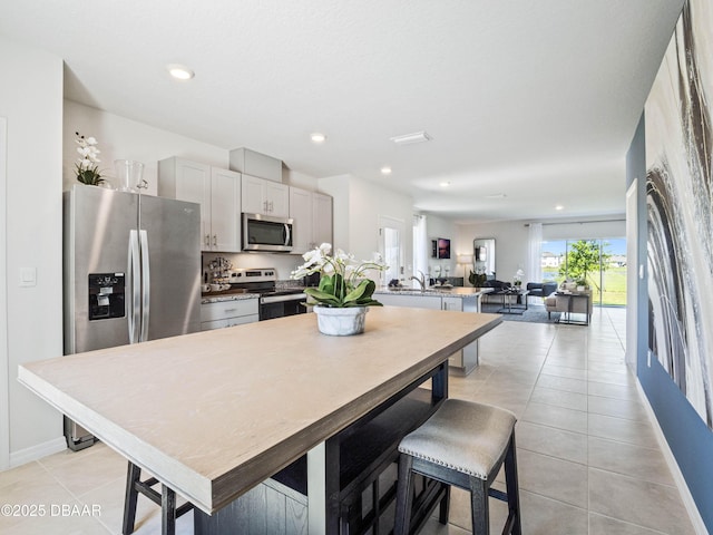 kitchen featuring stainless steel appliances, light tile patterned floors, and gray cabinetry