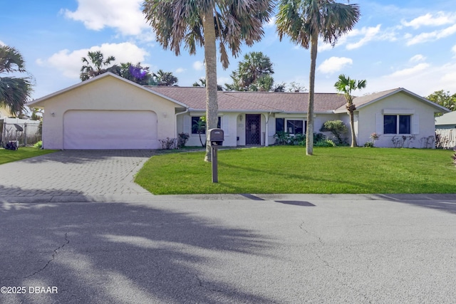 ranch-style home with an attached garage, fence, decorative driveway, stucco siding, and a front lawn