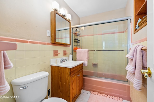 full bathroom featuring enclosed tub / shower combo, tile patterned floors, toilet, tile walls, and vanity