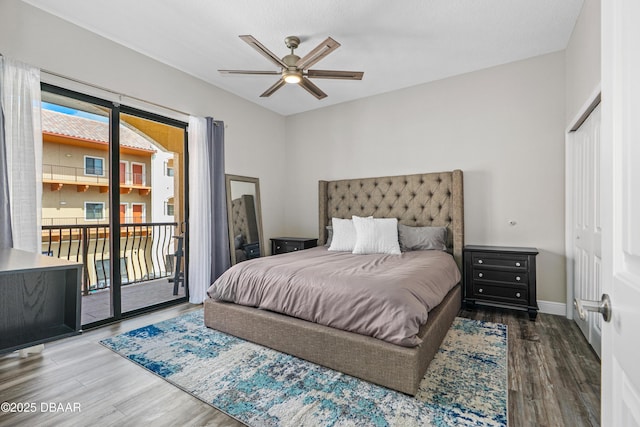 bedroom with baseboards, access to exterior, wood finished floors, and multiple windows