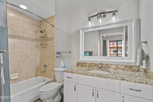 bathroom with washtub / shower combination, toilet, and vanity