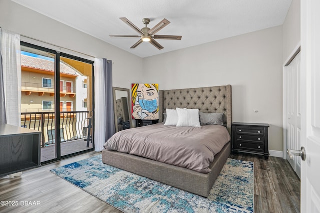 bedroom featuring baseboards, access to exterior, wood finished floors, and multiple windows