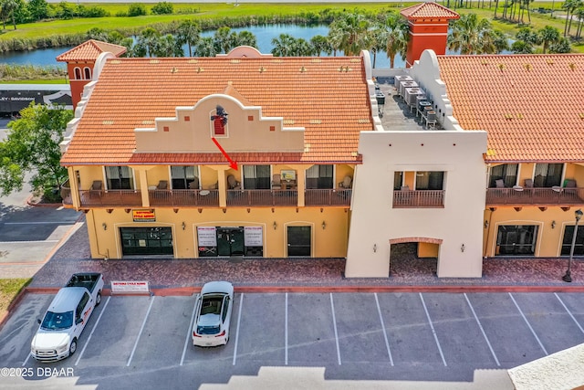 view of property with uncovered parking and a water view