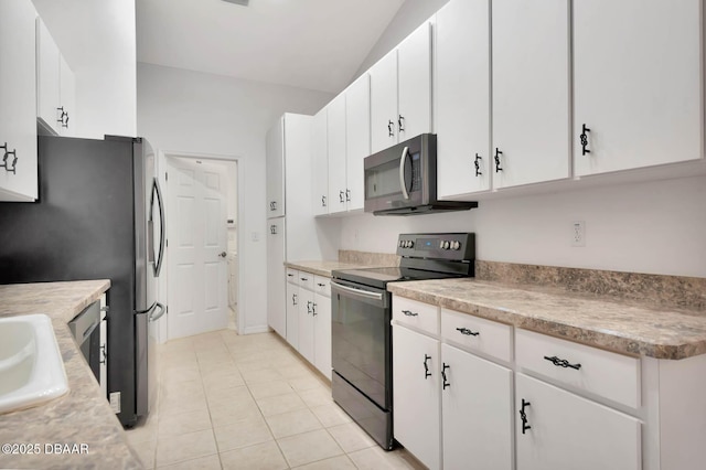 50 Spring Meadows Dr, Ormond Beach, FL 32174 - kitchen with stainless steel appliances, white cabinets, light tile patterned floors, light countertops, and lofted ceiling