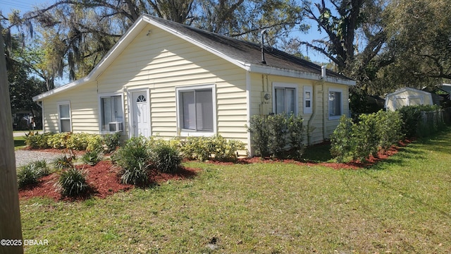 view of side of home featuring cooling unit and a yard