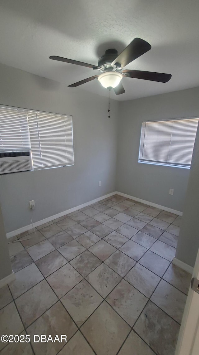 unfurnished room with light tile patterned floors, cooling unit, baseboards, and a ceiling fan