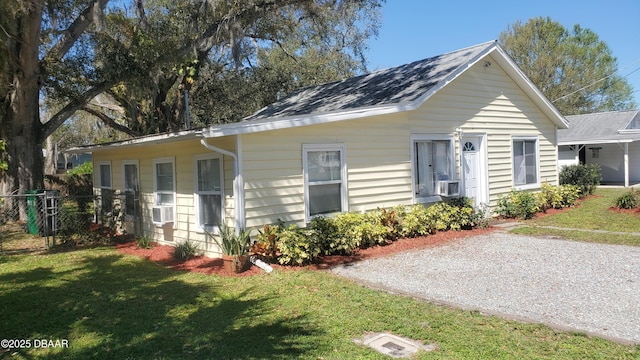 view of front of property featuring cooling unit, roof with shingles, a front yard, and fence