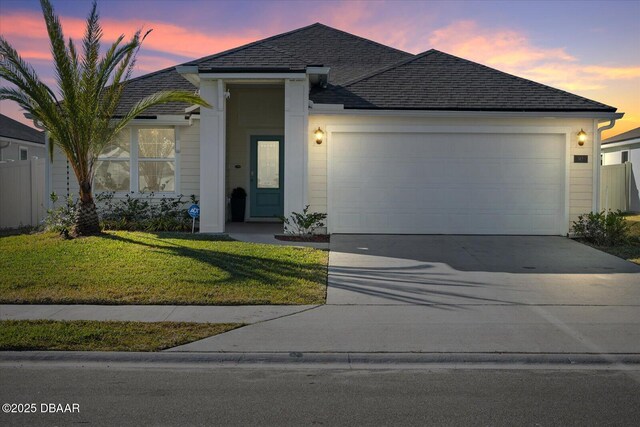 view of front of home featuring a garage and a lawn