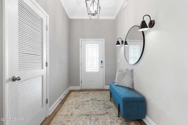 foyer featuring wood-type flooring, a chandelier, and ornamental molding