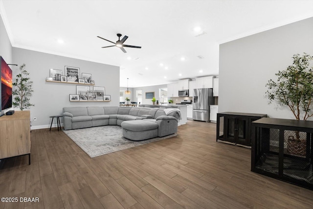 living room featuring ceiling fan, crown molding, and dark hardwood / wood-style floors