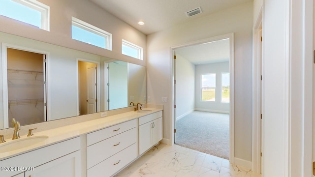 bathroom with double vanity, visible vents, marble finish floor, and a sink