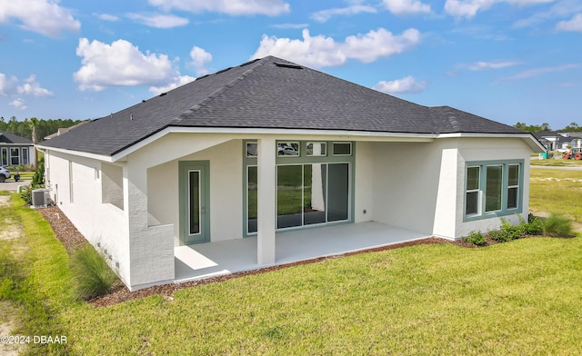 rear view of property with stucco siding, a patio, a lawn, and a shingled roof