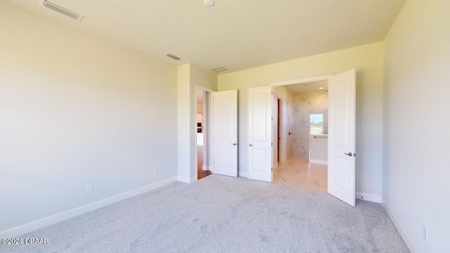 unfurnished bedroom with baseboards, visible vents, and carpet floors