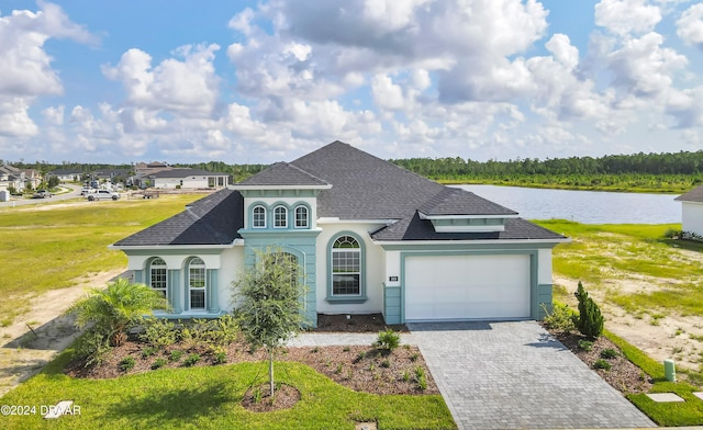 view of front of house featuring a garage, a water view, and a front yard