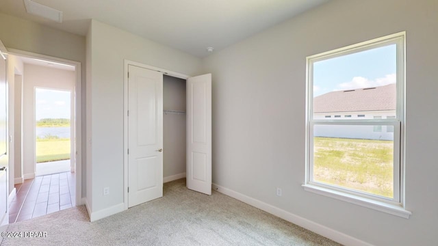 unfurnished bedroom with carpet flooring, multiple windows, and baseboards