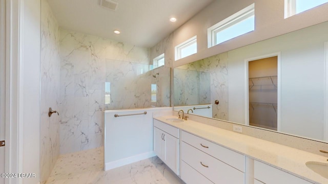 bathroom with visible vents, marble finish floor, a marble finish shower, and a sink