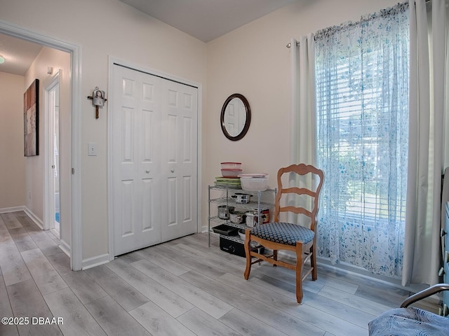 sitting room with light wood-type flooring and baseboards
