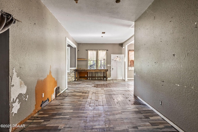 hallway with dark hardwood / wood-style flooring and a textured ceiling