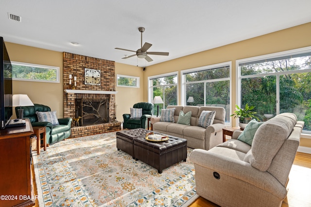 living room with a fireplace, light hardwood / wood-style floors, and ceiling fan