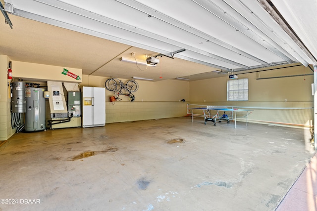 garage featuring a garage door opener, water heater, and white refrigerator with ice dispenser