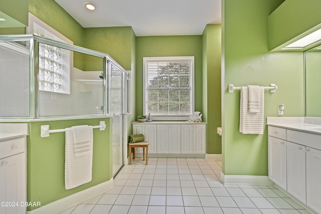 bathroom with a healthy amount of sunlight, tile patterned floors, and a shower with shower door