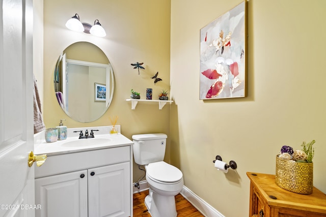 bathroom with hardwood / wood-style floors, vanity, and toilet