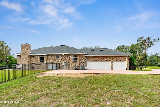 back of property featuring a garage and a yard