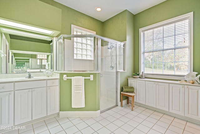 bathroom featuring a wealth of natural light, tile patterned floors, and a shower with door