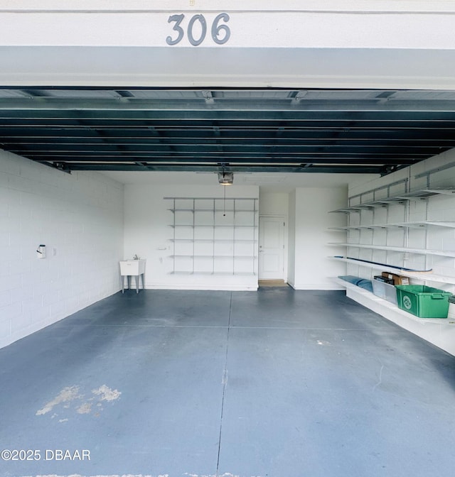 306 Coral Reef Way, Daytona Beach, FL 32124 - garage featuring a garage door opener and concrete block wall