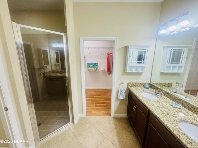306 Coral Reef Way, Daytona Beach, FL 32124 - bathroom featuring double vanity, a shower stall, tile patterned floors, and a spacious closet