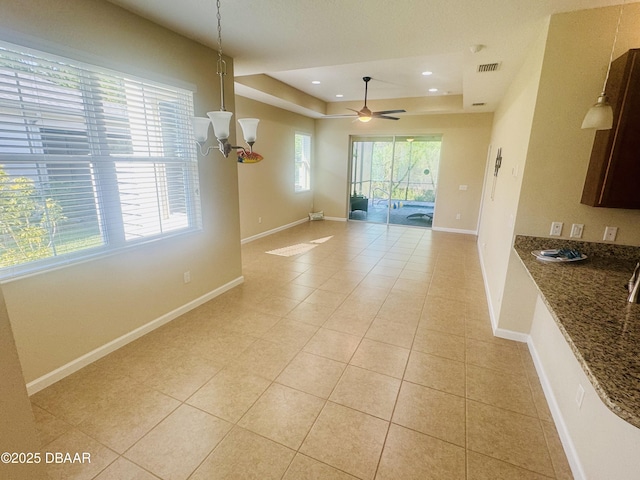 306 Coral Reef Way, Daytona Beach, FL 32124 - unfurnished dining area featuring a tray ceiling, light tile patterned flooring, ceiling fan, a chandelier, and recessed lighting