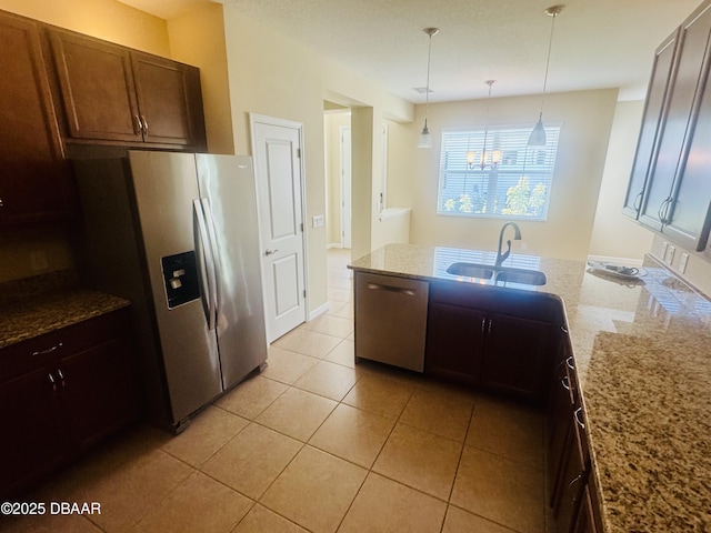 306 Coral Reef Way, Daytona Beach, FL 32124 - kitchen featuring appliances with stainless steel finishes, a peninsula, light stone countertops, decorative light fixtures, and light tile patterned floors
